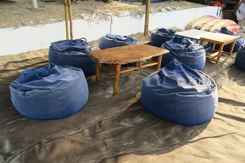 印度果阿度假的Palolem海滩度假餐厅的蓝色豆袋，太阳躺椅/豆袋，桌子